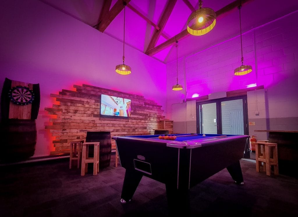 Archway room at a golf in Bristol with a pool table, dart board, and TV for social events.