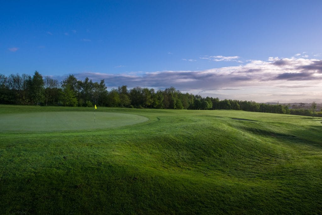 Golf hole under a dim sky with neatly cut grass at a golf course in Bristol.