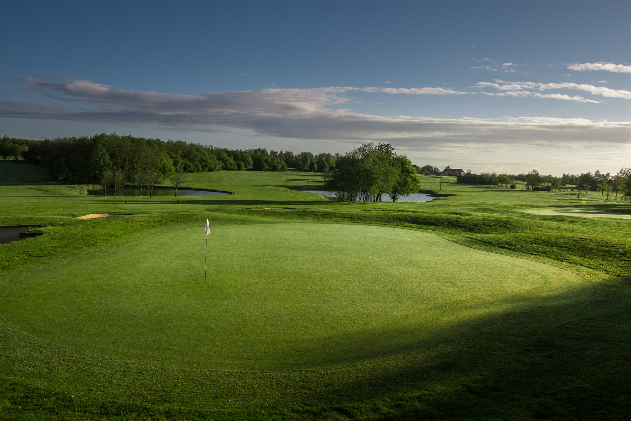 Golf hole green beside water at a golf course in Bristol.