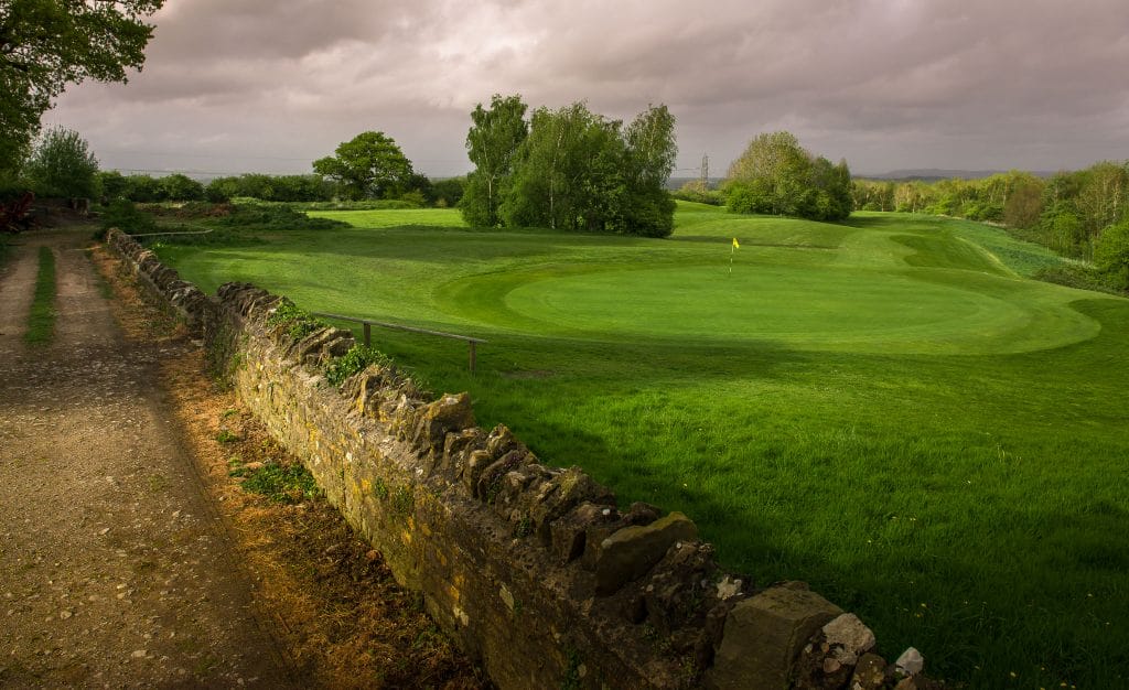 cobblestone wall overlooking golf course in bristol surrounded by countryside