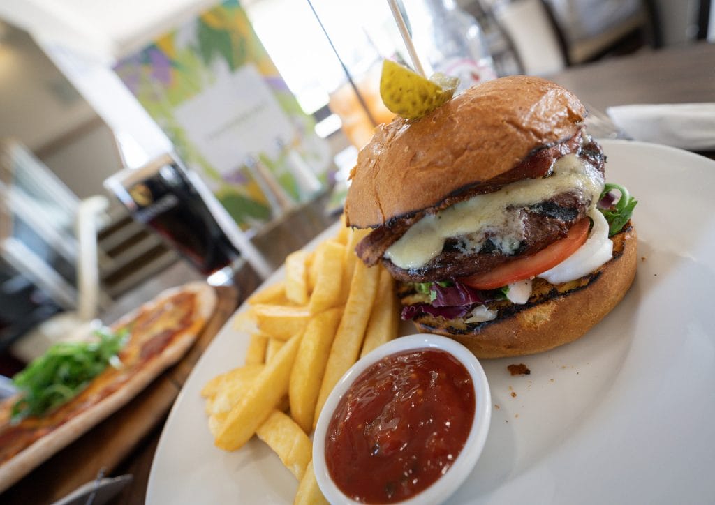 "Freshly made burger with fries at a vibrant restaurant in Bristol, ideal for food lovers near Alveston