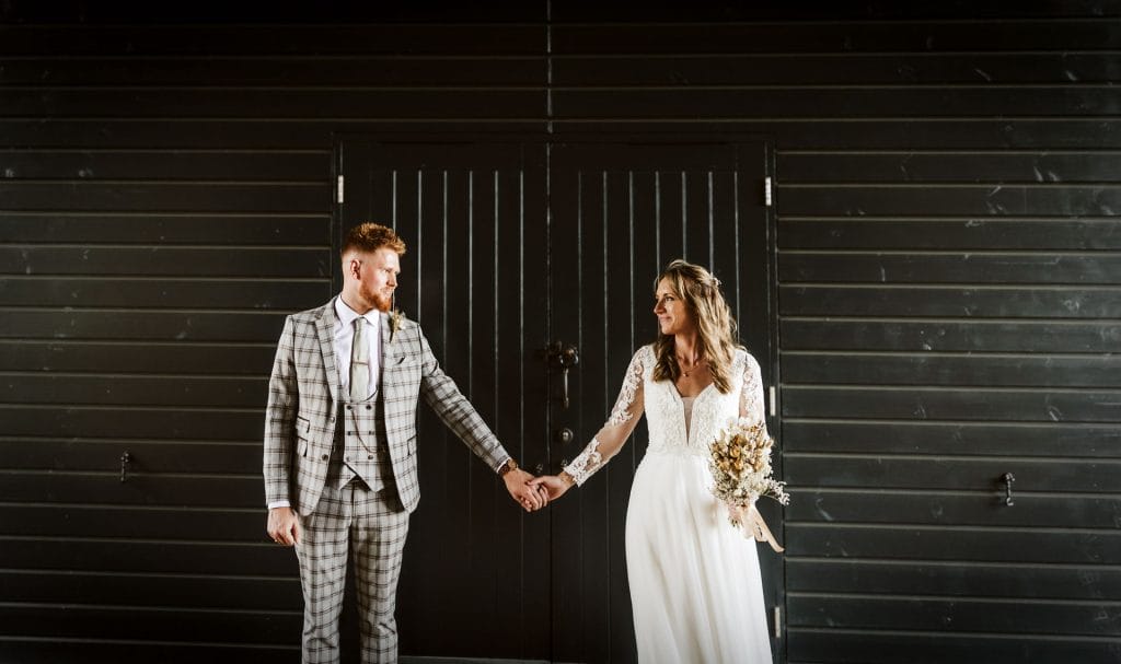 married couple holding hands gazing into each other eyes at wedding venue in bristol