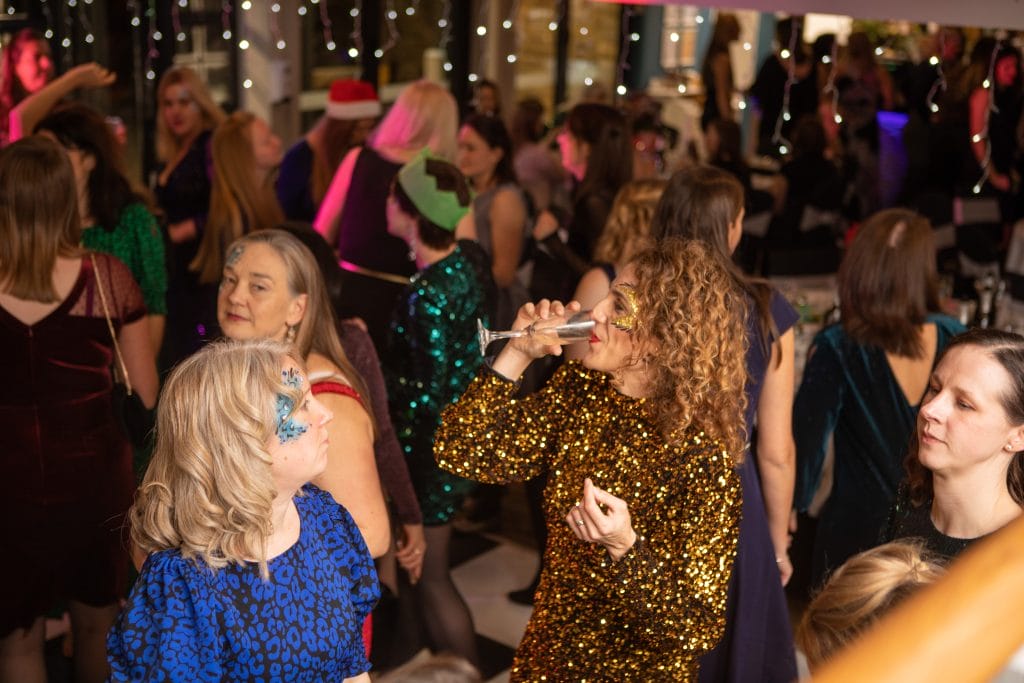 people dancing with drinks at a christmas party venue in bristol