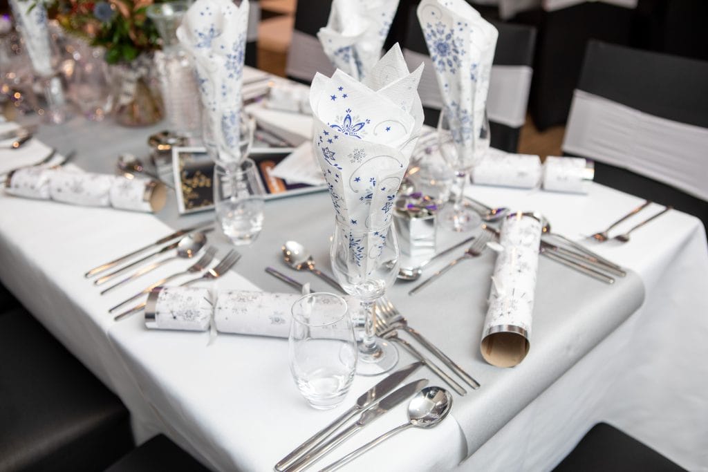 christmas table with cutlery, tissues and christmas crackers