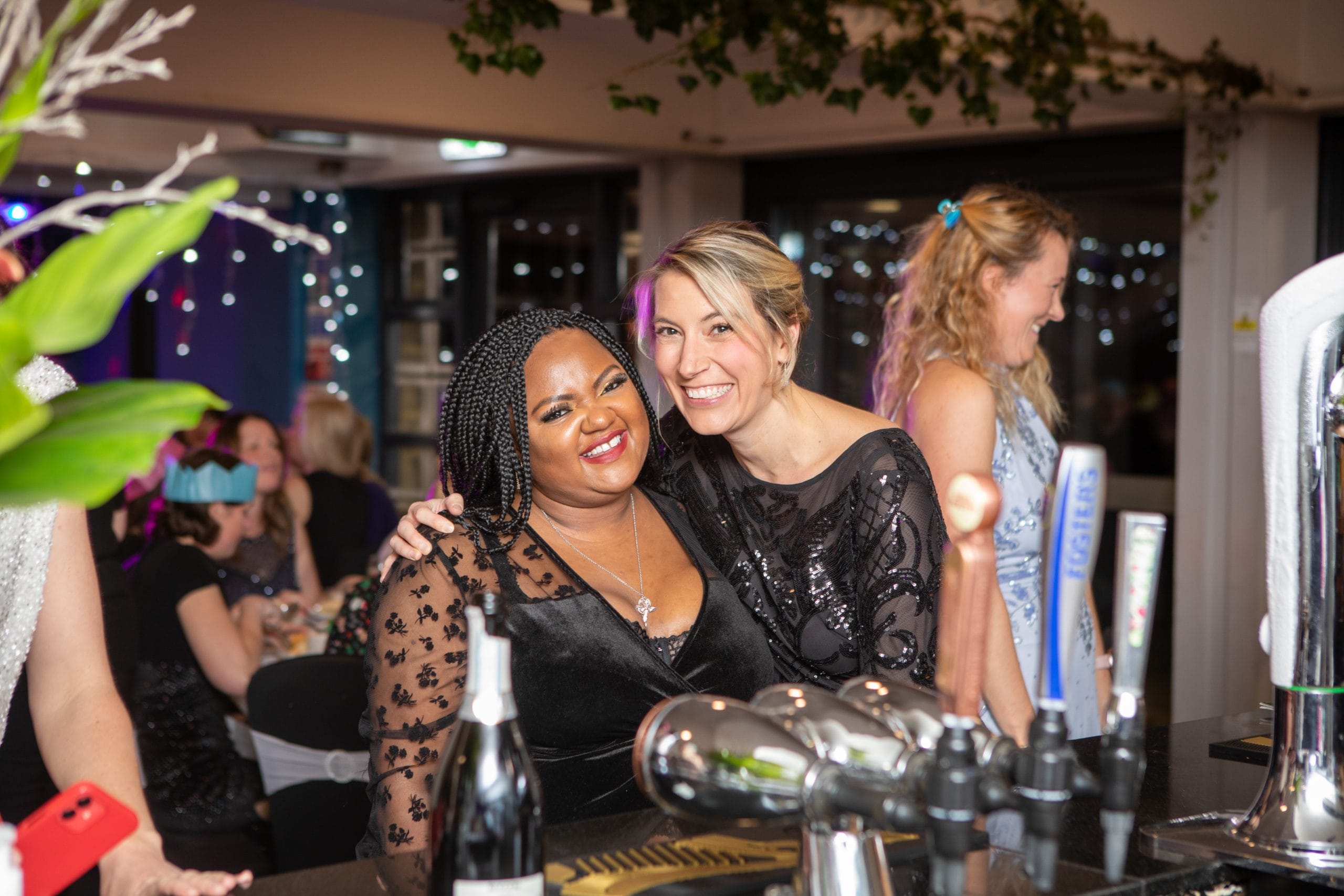 two woman stood at the bar smiling at a christmas party in bristol