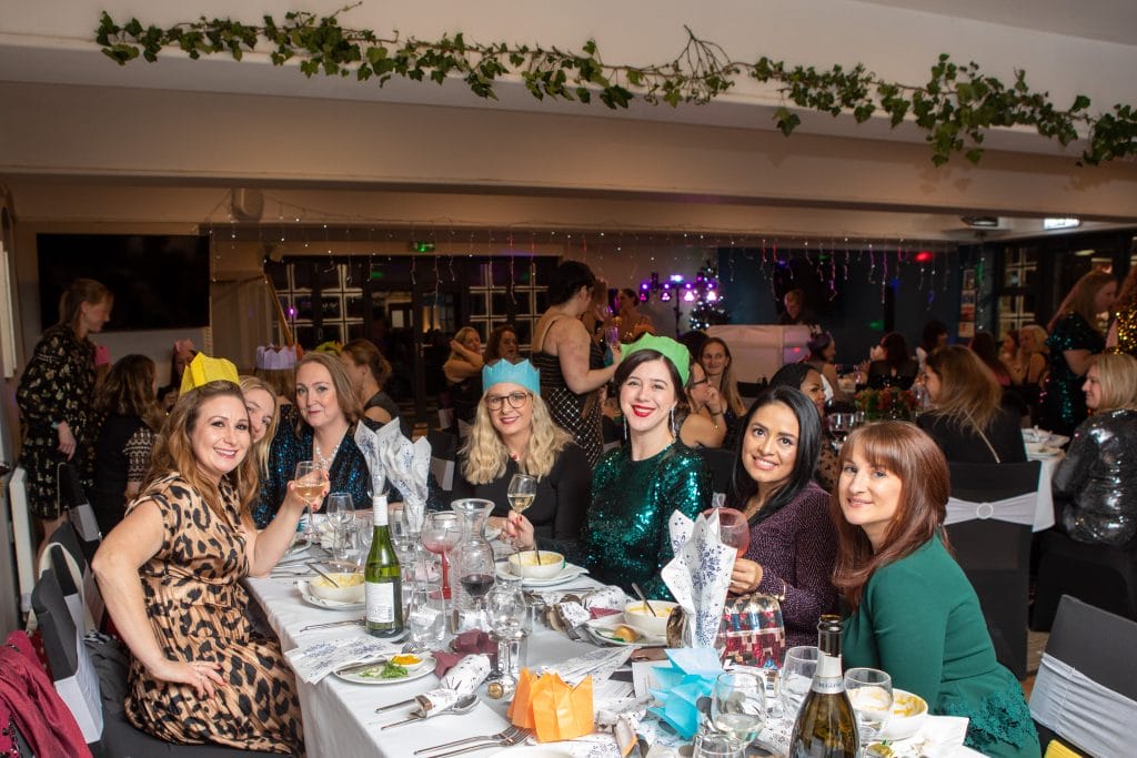 group of ladies smiling at table at a christmas party in bristol