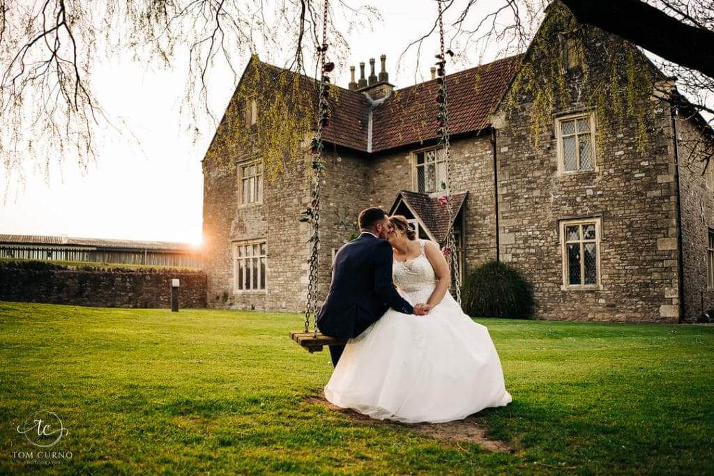 newly married couple sat on tree swing at thornbury lodge after their wedding near bristol
