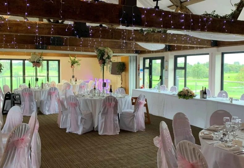 Elegant indoor wedding venue at Thornbury Golf and Lodge with decorated tables and panoramic views of the golf course near Bristol