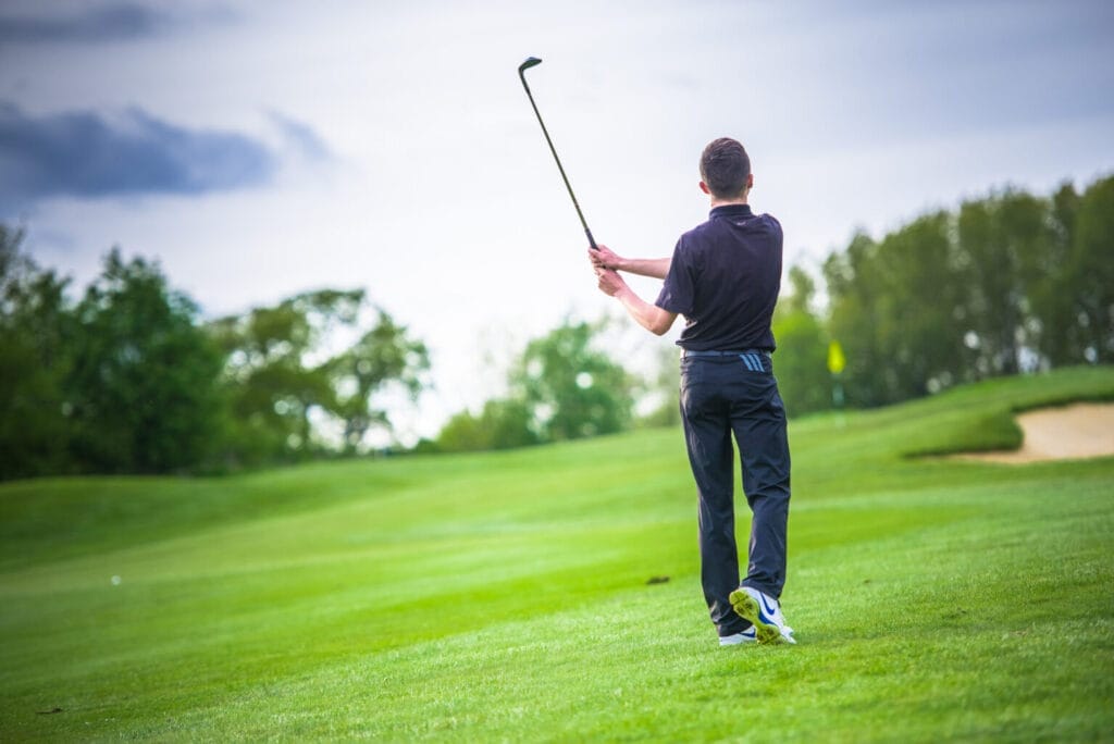 young man hitting into green after purchasing junior golf membership in bristol